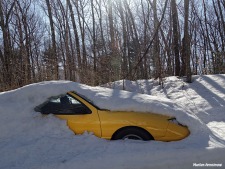 yellow car emerging from snow